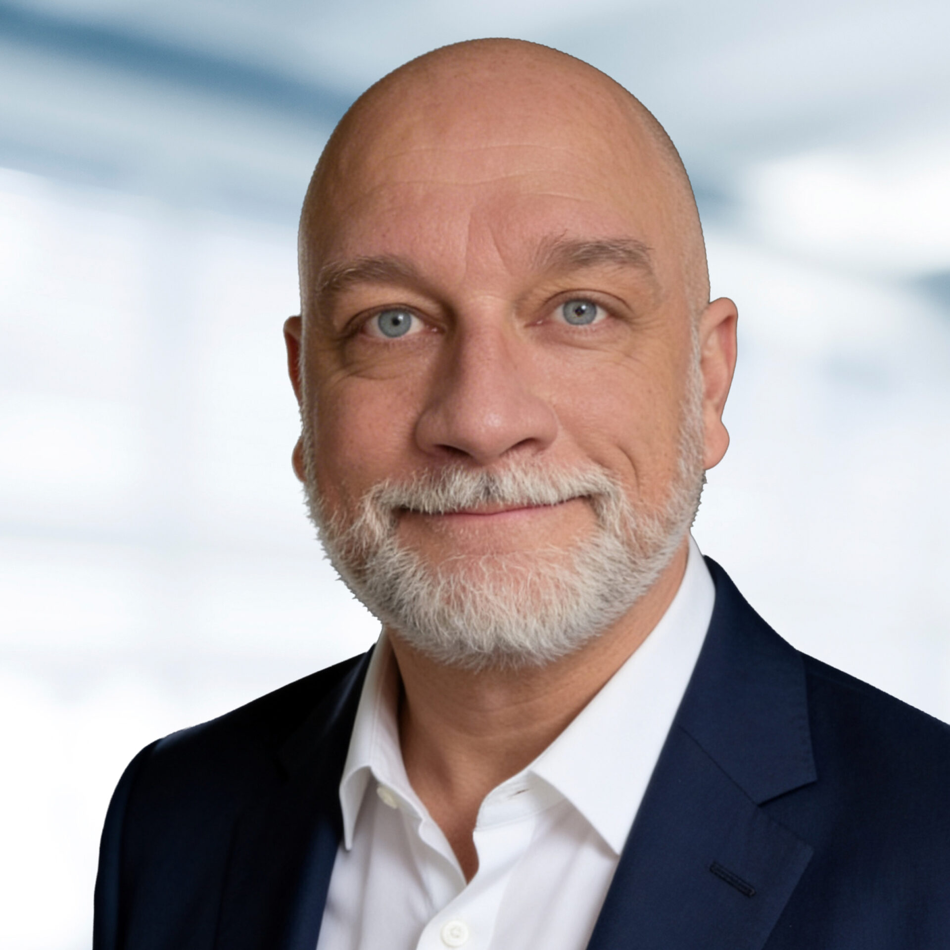 Sven Homburg trägt einen Anzug mit Krawatte. Der Hintergrund ist unscharf und zeigt ein Büro.