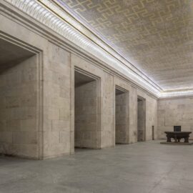 Innenraum der Zeppelintribüne mit monumentaler Natursteinarchitektur, hohen Säulen und der restaurierten Goldmosaikdecke im ehemaligen Goldenen Saal.
