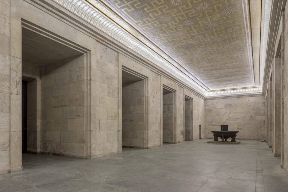 Innenraum der Zeppelintribüne mit monumentaler Natursteinarchitektur, hohen Säulen und der restaurierten Goldmosaikdecke im ehemaligen Goldenen Saal.