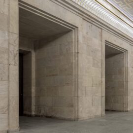 Innenraum der Zeppelintribüne mit monumentaler Natursteinarchitektur, hohen Säulen und der restaurierten Goldmosaikdecke im ehemaligen Goldenen Saal.