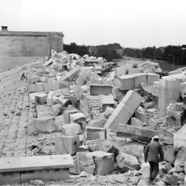 Historische Aufnahme der gesprengten Haupttribüne des Zeppelinfelds mit großen Trümmerblöcken nach dem Ende des Zweiten Weltkriegs.