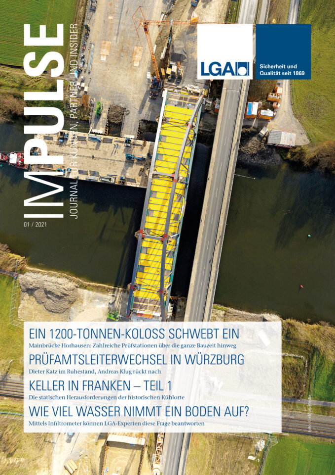 Auf dem Bild ist das Titelblatt einer Zeitschrift mit dem Namen „IMPULSE JOURNAL“ zu sehen. Es zeigt eine Luftaufnahme einer großen Baustelle mit einer im Bau befindlichen Brücke über ein Gewässer. Kräne und Baumaschinen sind auf beiden Uferseiten zu erkennen.