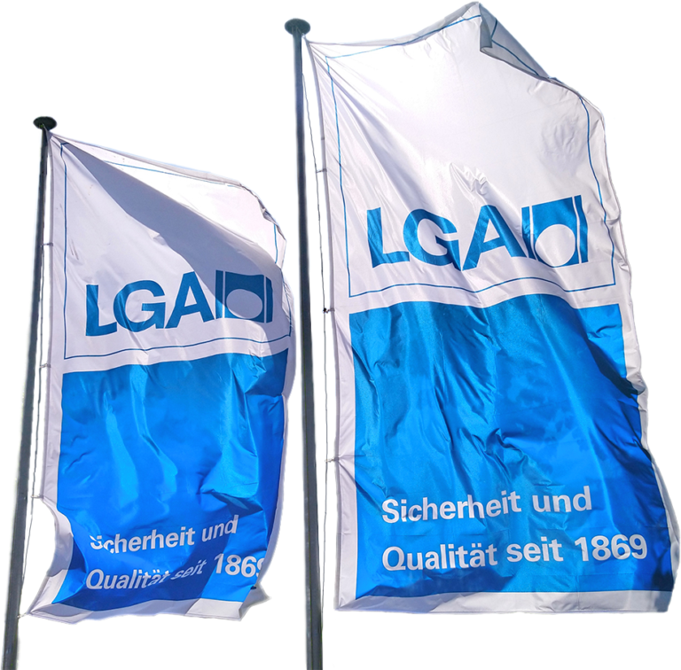 Zwei freigestellte LGA Fahnen mit der Aufschrift Sicherheit und Qualität seit 1869.