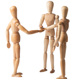 Das Bild zeigt drei hölzerne Künstlerfiguren. Die Figuren legen ihre Hände in der Mitte aufeinander. Die Anordnung der Figuren vermittelt den Eindruck eines Gesprächs oder einer Einigung.