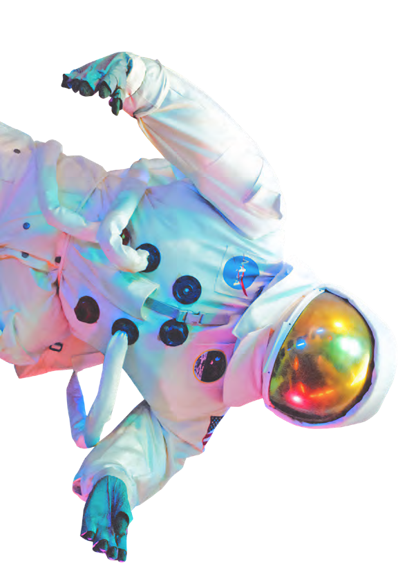 Das Bild zeigt einen Astronauten in einem weißen Raumanzug. Der Helm hat ein goldfarbenes, spiegelndes Visier, und der Anzug ist mit schwarzen Anschlüssen und Schläuchen versehen. Der Raumanzug ist hell ausgeleuchtet und zeigt bunte Lichtreflexionen.