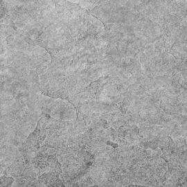 Das Bild zeigt eine Nahaufnahme einer grauen, strukturierten Oberfläche, die an Beton oder Stein erinnert. Über die Fläche ziehen sich verschiedene Risse und unregelmäßige Muster.