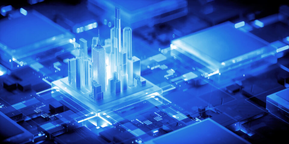 Das Bild zeigt eine futuristische Stadtlandschaft mit leuchtend blauen Hochhäusern in digitalem Stil. Die Gebäude stehen auf einer Fläche, die an eine Leiterplatte erinnert, wodurch sich Architektur und Technologie visuell verbinden. Die Darstellung betont eine moderne, technologisch geprägte Umgebung.