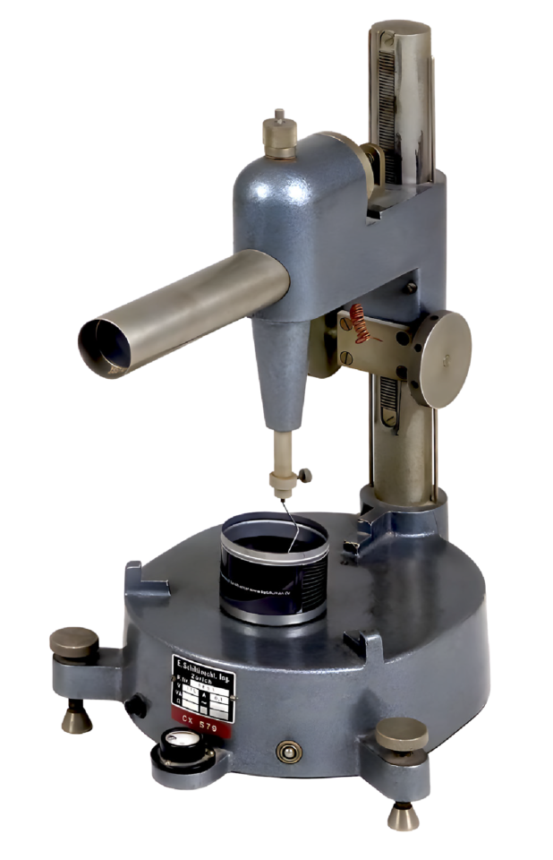 Das Bild zeigt ein Präzisionsmessgerät, vermutlich ein Höhenmessgerät oder eine Messuhr. Es steht auf einem zylindrischen Sockel mit drei verstellbaren Füßen zur Nivellierung. Eine senkrechte Säule mit Skala und ein verstellbarer Arm mit Messfühler ermöglichen genaue Höhen- oder Maßbestimmungen eines darunterliegenden Objekts.
