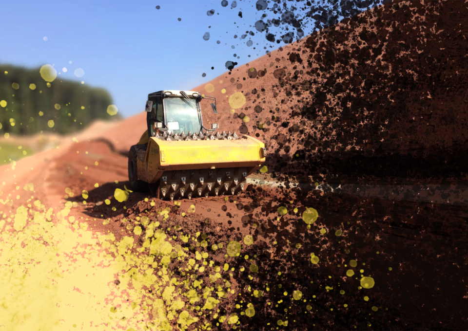 Das Bild zeigt ein schweres Baustellenfahrzeug, einen Bodenverdichter mit stacheligen Walzen, das auf einem unbefestigten Weg arbeitet. Im Hintergrund sind ein klarer blauer Himmel und etwas Grünfläche auf der linken Seite zu sehen. Teile des Bildes sind mit gelben und schwarzen Farbeffekten künstlerisch überlagert.