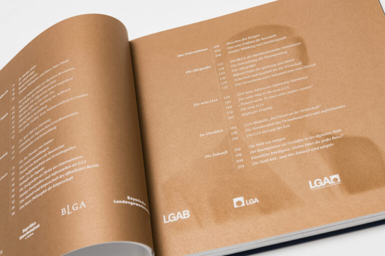 Das Bild zeigt ein aufgeschlagenes Buch mit bronzenen Seiten. Auf beiden Seiten ist ein Inhaltsverzeichnis mit mehreren Kapiteln und Seitenzahlen in deutscher Sprache zu sehen.