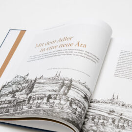 Das Bild zeigt ein aufgeschlagenes Buch mit Text und Illustrationen über beide Seiten. Es wird die Jungfernfahrt der ersten deutschen Eisenbahn von Nürnberg nach Fürth im Jahr 1835 beschrieben.