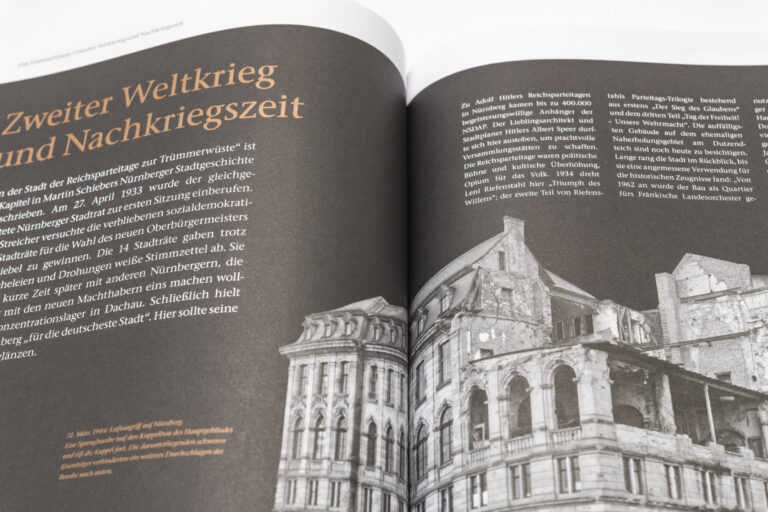 Das Bild zeigt ein geöffnetes Buch mit deutschem Text und einer schwarz-weißen Fotografie eines beschädigten Gebäudes. Der Text behandelt den Zweiten Weltkrieg und die Nachkriegszeit in Nürnberg. Die Fotografie zeigt Gebäuderuinen als Folge der Zerstörung im Krieg.