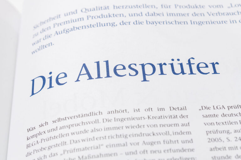 Das Bild zeigt eine Seite aus einem Buch mit dem Titel „Die Allesprüfer“ in großer blauer Schrift. Darunter befindet sich ein Absatz in kleinerer Schrift, der die anspruchsvolle Arbeit einer Prüfstelle beschreibt. Am oberen Rand ist teilweise weiterer Text sichtbar, der sich mit Sicherheit und Qualität von Produkten befasst.
