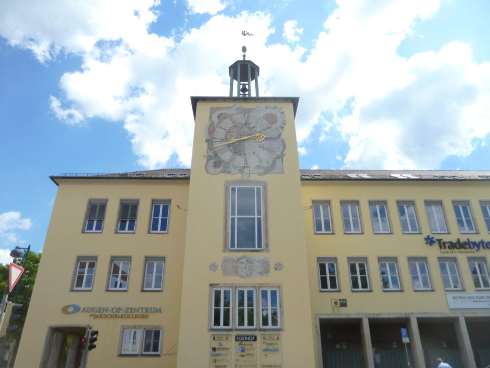 Ansicht des gelben Gebäudes mit Uhrturm in Ansbach bei sonnigem Wetter.