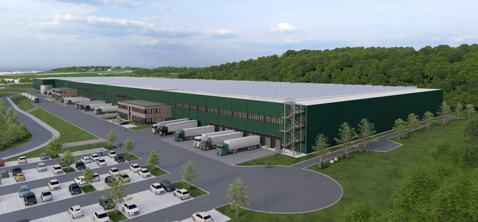 Das Bild zeigt ein grafisches Modell eines großen Industrie- oder Logistikzentrum mit grüner Fassade, mehreren Laderampen mit parkenden Lkw sowie einem Parkplatz im Vordergrund, umgeben von Bäumen und Grünflächen in ländlicher oder vorstädtischer Umgebung.