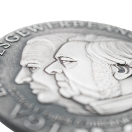 Anschnitt silberne Medaille mit zwei geprägten Profilen.